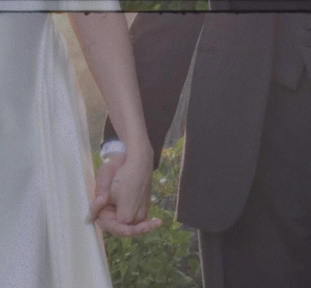 close-up of bride and groom holding hands during intimate outdoor wedding
